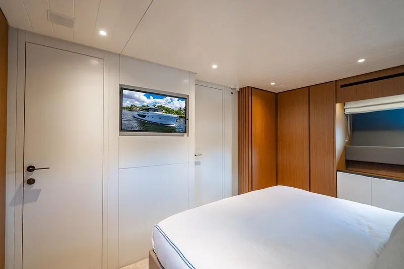 Snack Money Yacht Photos Pics Luxurious interior of 2023 Bluegame BG 72 yacht with modern wood paneling and TV.