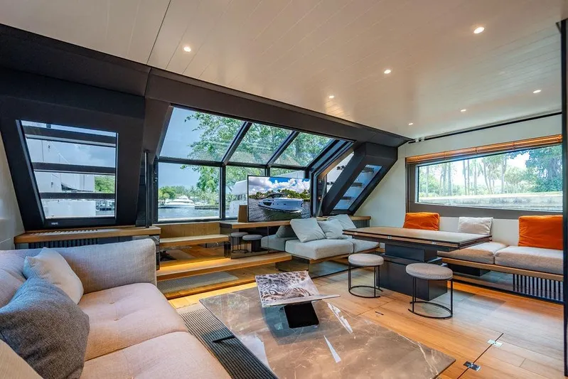 Snack Money Yacht Photos Pics Luxurious interior of 2023 Bluegame BG 72 yacht with modern seating and large windows.