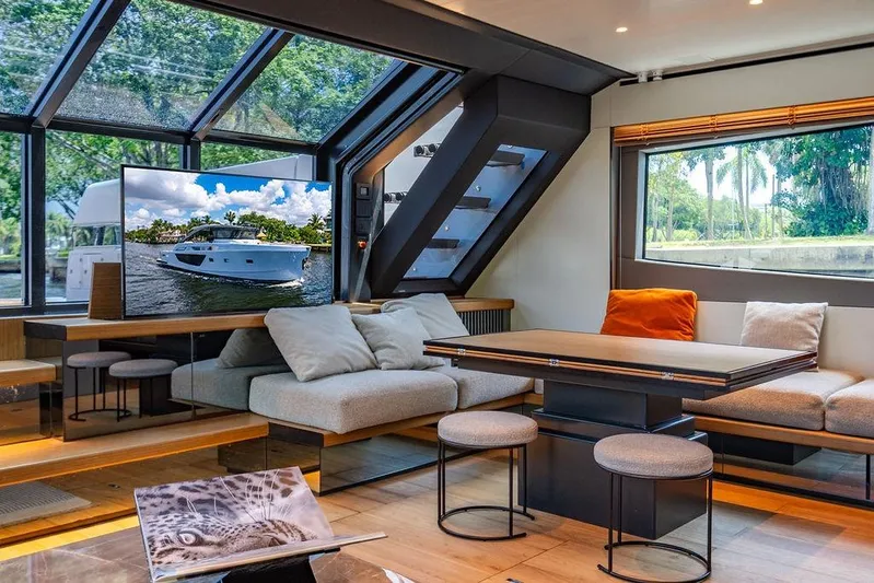 Snack Money Yacht Photos Pics Luxurious interior of 2023 Bluegame BG 72 yacht with modern seating and large windows.