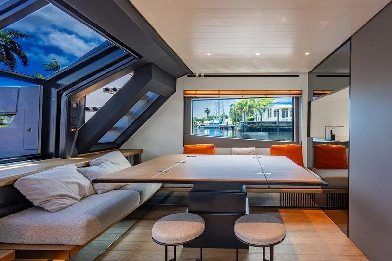 Snack Money Yacht Photos Pics Luxurious interior of 2023 Bluegame BG 72 yacht with modern seating and large windows.