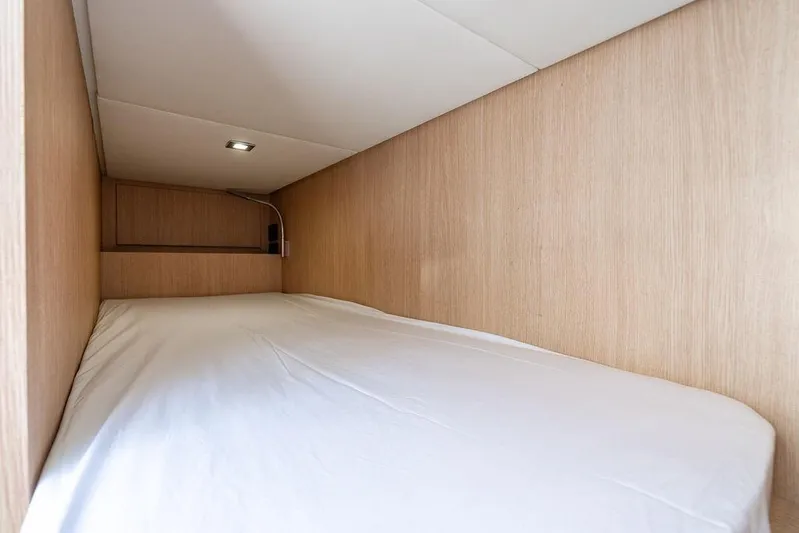Snack Money Yacht Photos Pics 2023 Bluegame BG 72 yacht cabin with minimalist wooden interior and cozy bed.