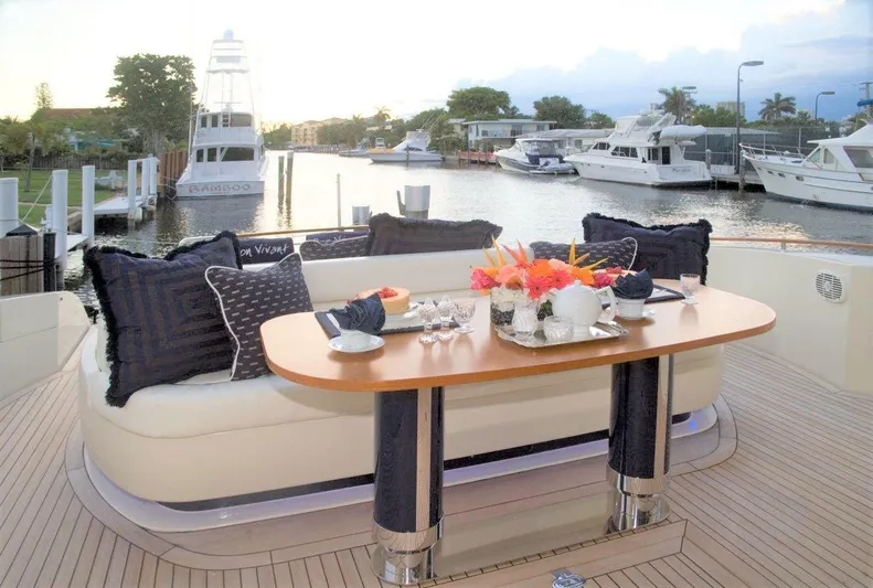 Bon Vivant Yacht Photos Pics Luxury dining setup on a 2004 Riva Splendida yacht with marina view.
