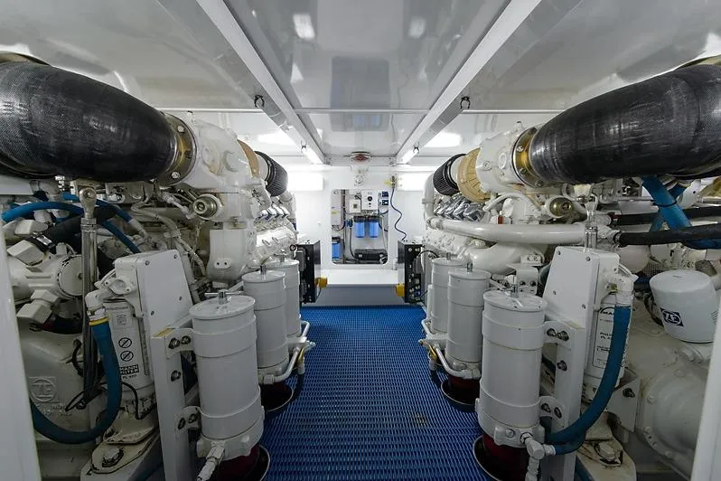 Ship's Cafe Yacht Photos Pics Engine room of 1987 Merritt Boat Works Sport Fisherman, featuring dual engines and blue flooring.