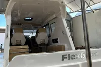2022 Flexboat FLEX 680 EXPLORE in a covered dock, showcasing interior seating and helm.