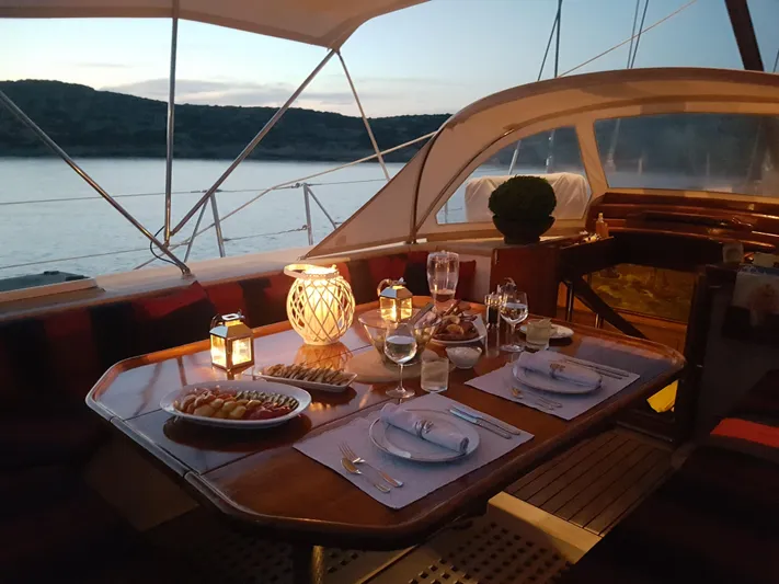 Wind Of Change Yacht Photos Pics Elegant dining setup on a 1988 Motorsailer Brooke Marine yacht at sunset.