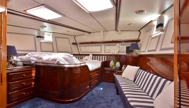 Wind Of Change Yacht Photos Pics Luxurious cabin interior of 1988 Brooke Marine Motorsailer with elegant wood finish and striped seating.