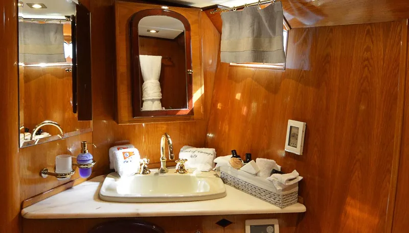 Wind Of Change Yacht Photos Pics Luxurious bathroom in a 1988 Brooke Marine Motorsailer with wooden cabinetry and modern fixtures.