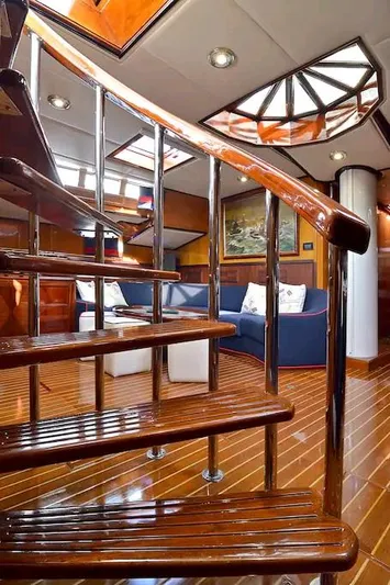 Wind Of Change Yacht Photos Pics Luxurious interior of 1988 Motorsailer Brooke Marine with wooden spiral staircase.