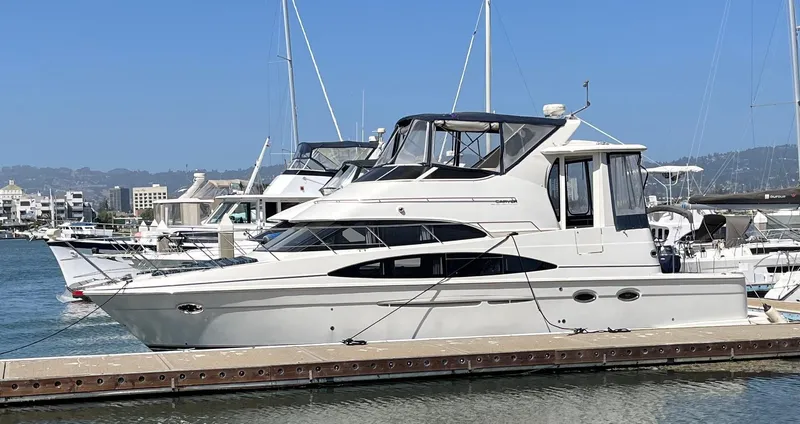 One In A Million Yacht Photos Pics 2005 Carver 444 yacht docked at a marina on a sunny day.