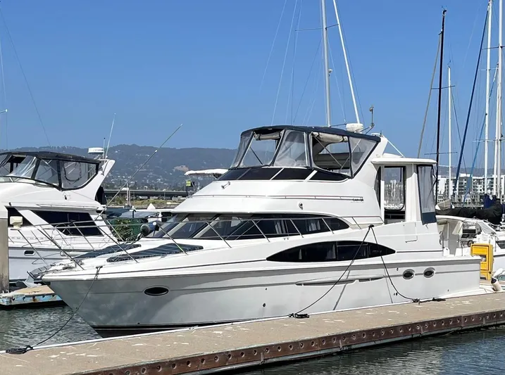One In A Million Yacht Photos Pics 2005 Carver 444 yacht docked at marina, clear sky, surrounded by other boats.