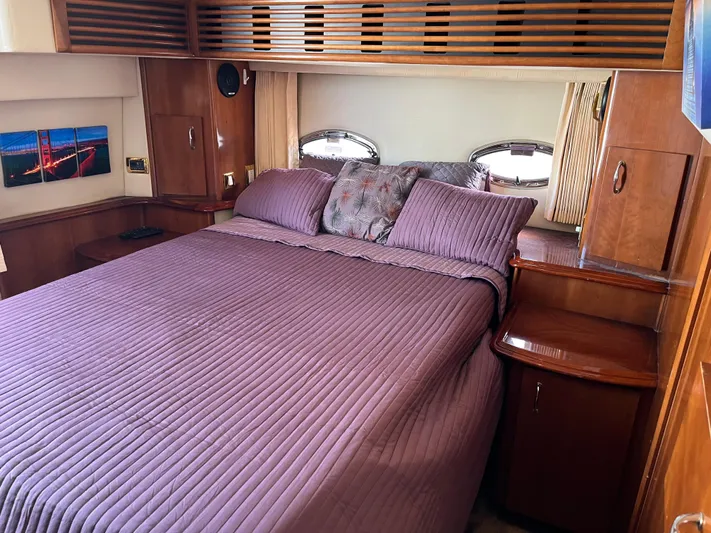 One In A Million Yacht Photos Pics Luxurious bedroom interior of a 2005 Carver 444 yacht with purple bedding.