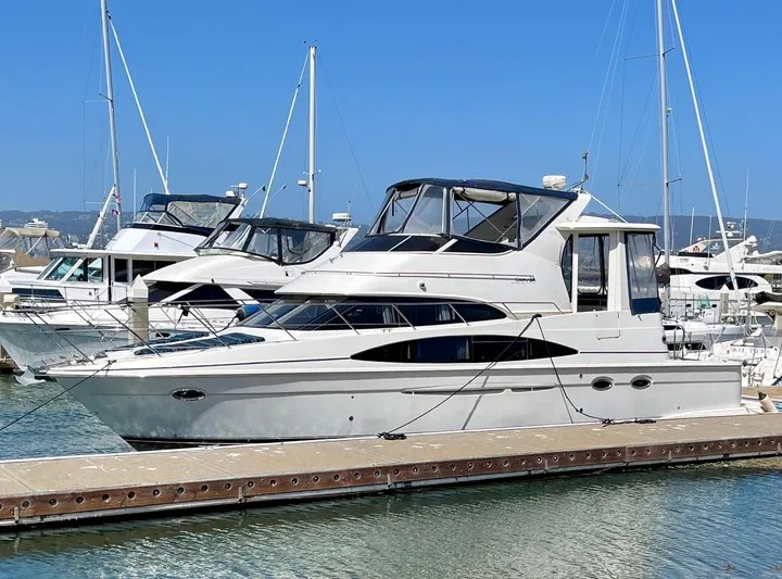 One In A Million Yacht Photos Pics 2005 Carver 444 yacht docked at marina, clear blue sky background.