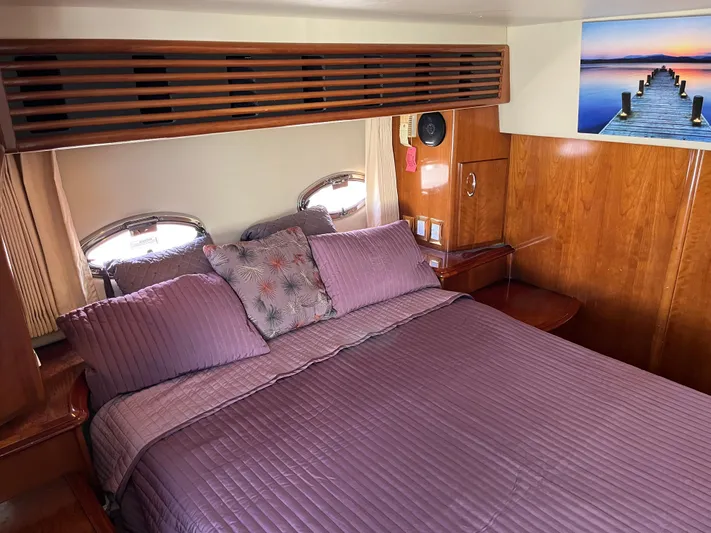 One In A Million Yacht Photos Pics Luxurious bedroom interior of 2005 Carver 444 yacht with wooden accents and purple bedding.
