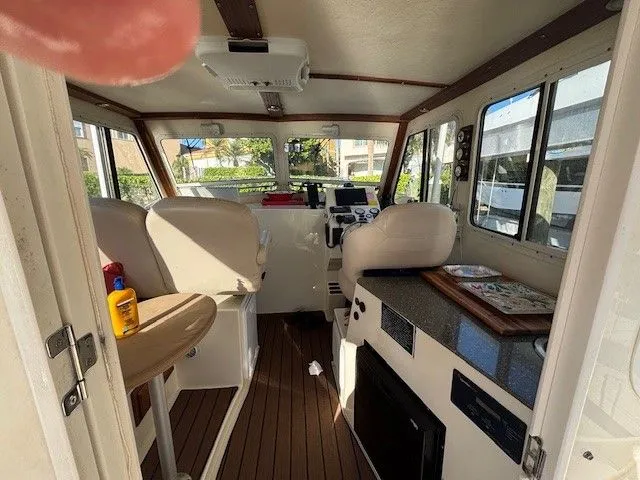 Rhode Waves Yacht Photos Pics Interior of a 2018 Eastern 27 Islander Hardback boat with seating and helm.