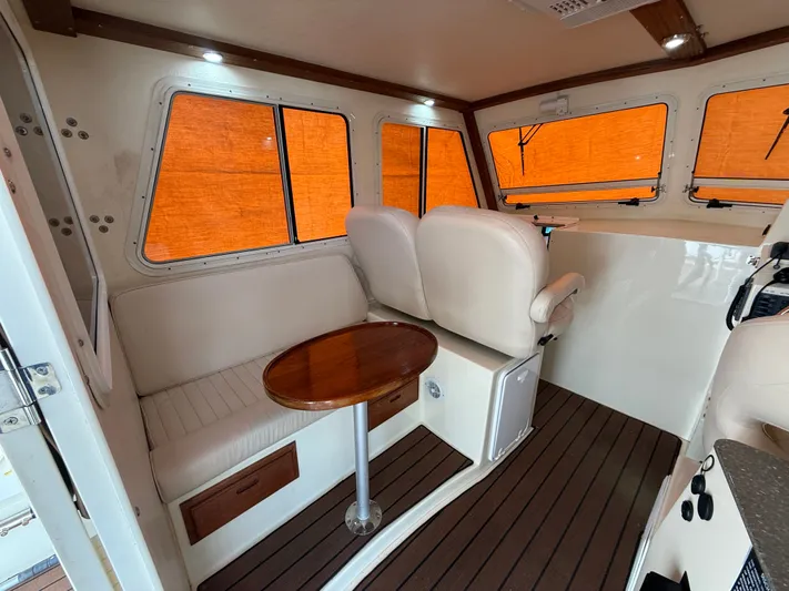 Rhode Waves Yacht Photos Pics Interior of a 2018 Eastern 27 Islander Hardback boat with seating area.