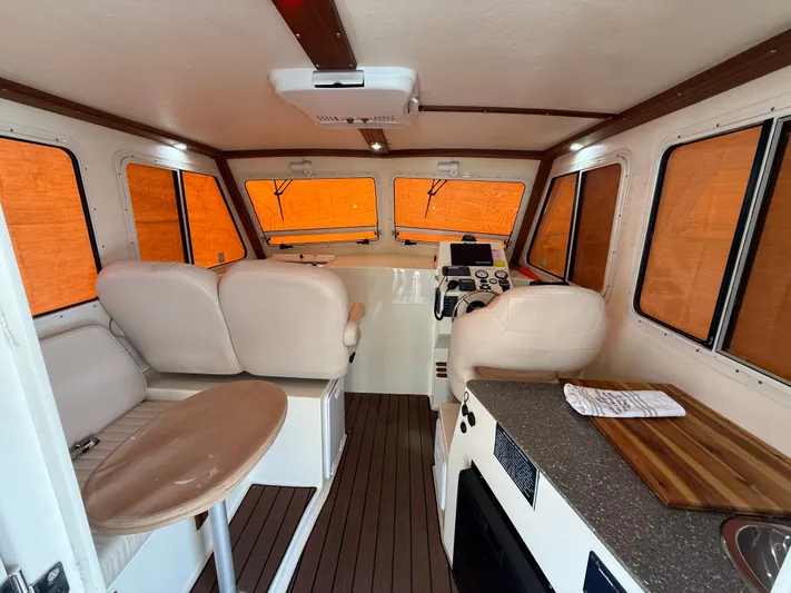 Rhode Waves Yacht Photos Pics Interior of a 2018 Eastern 27 Islander Hardback boat with seating and helm.