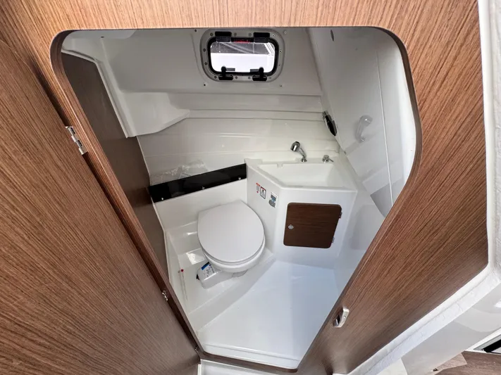  Yacht Photos Pics 2025 Beneteau Antares 8 boat bathroom with modern fixtures and wood accents.
