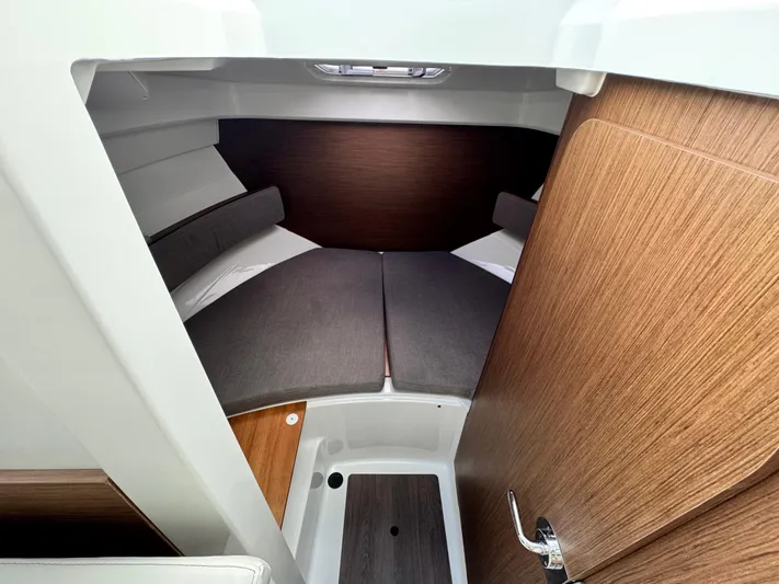  Yacht Photos Pics 2025 Beneteau Antares 8 cabin interior with cozy bedding and wooden accents.