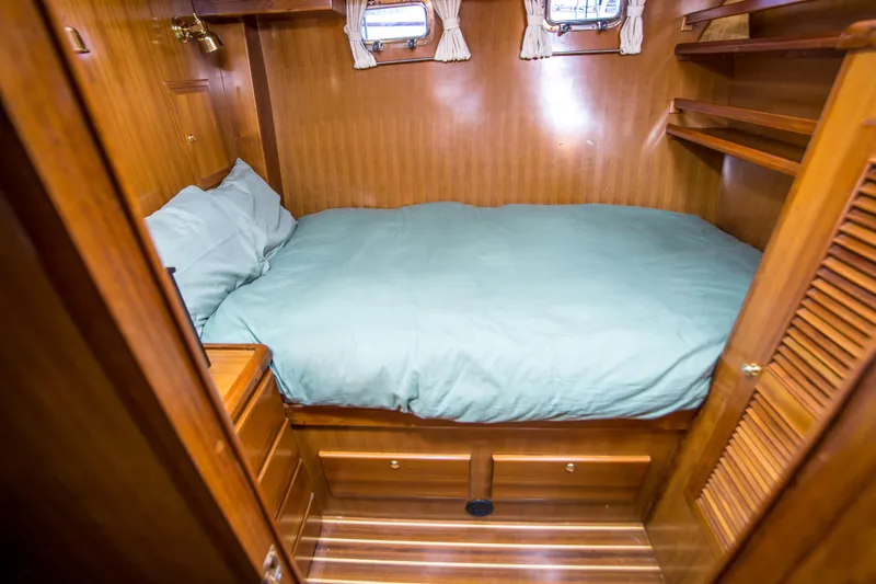Papagayo Yacht Photos Pics Cozy cabin interior of 2008 North Pacific 43 Pilothouse with wooden finish and bed.