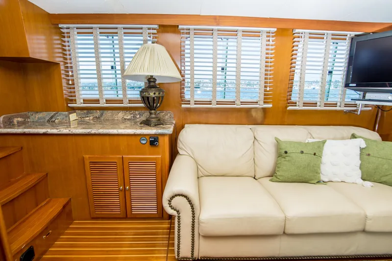 Papagayo Yacht Photos Pics Interior of 2008 North Pacific 43 Pilothouse with sofa, lamp, and TV.