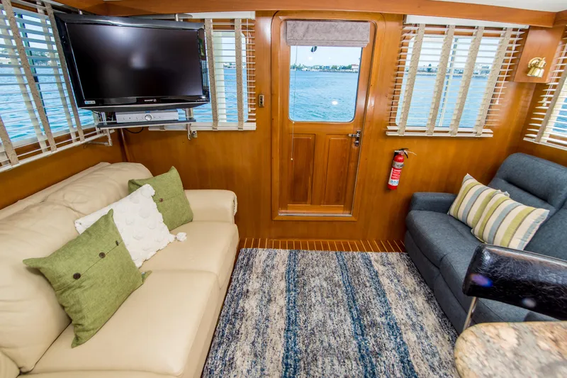 Papagayo Yacht Photos Pics Interior of 2008 North Pacific 43 Pilothouse with cozy seating, TV, and ocean view.