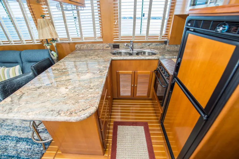 Papagayo Yacht Photos Pics Luxurious 2008 North Pacific 43 Pilothouse yacht interior with granite countertops and wooden cabinetry.