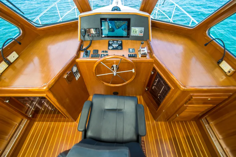 Papagayo Yacht Photos Pics Pilothouse interior of 2008 North Pacific 43, featuring wooden helm and navigation equipment.