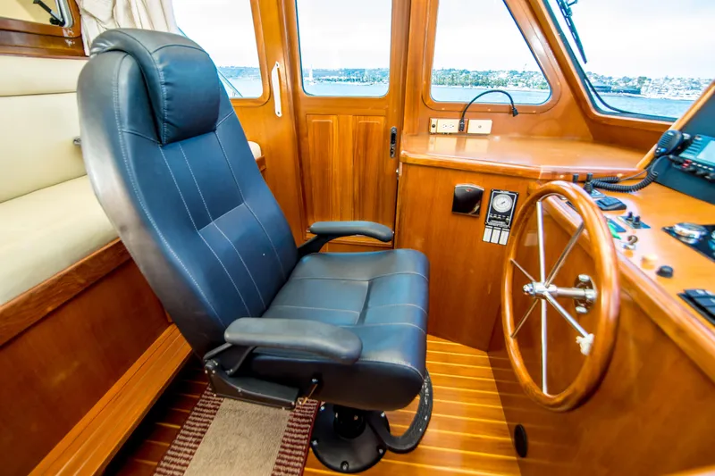 Papagayo Yacht Photos Pics Pilothouse interior of 2008 North Pacific 43, featuring captain's chair and steering wheel.