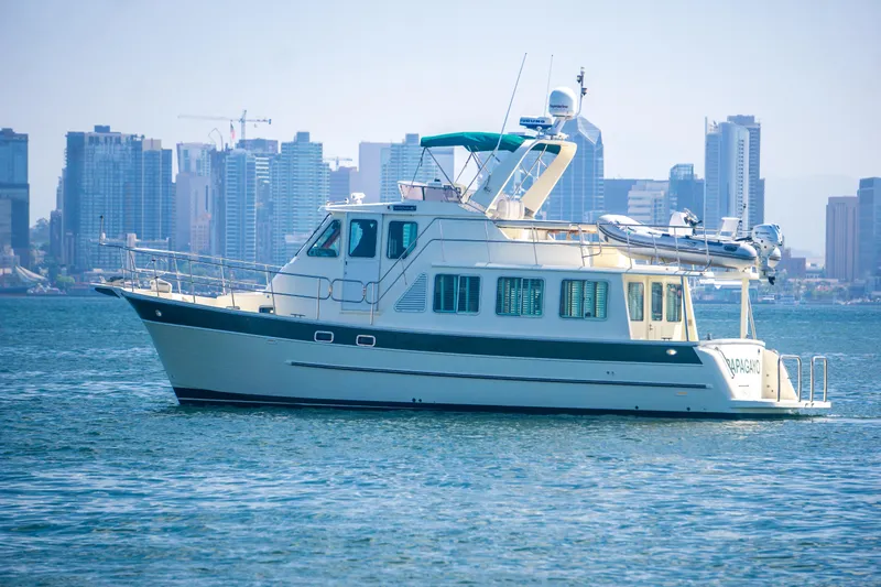 Papagayo Yacht Photos Pics 2008 North Pacific 43 Pilothouse yacht cruising near city skyline.