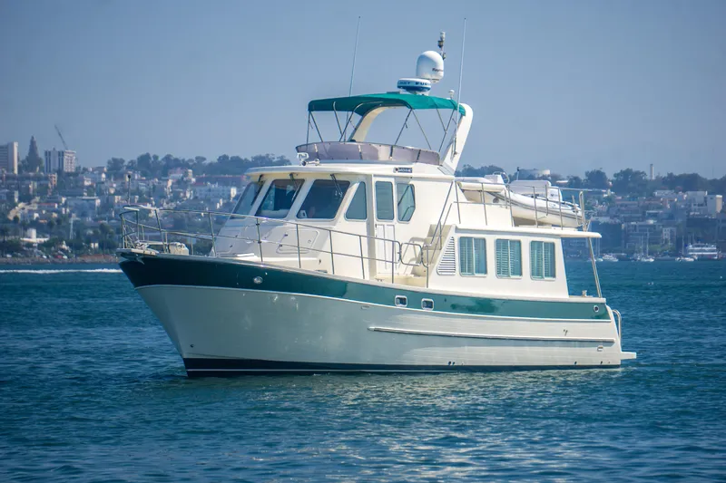 Papagayo Yacht Photos Pics 2008 North Pacific 43 Pilothouse yacht on calm water with cityscape background.