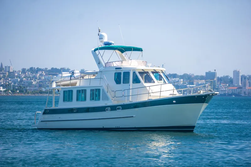 Papagayo Yacht Photos Pics 2008 North Pacific 43 Pilothouse yacht on calm water with cityscape background.