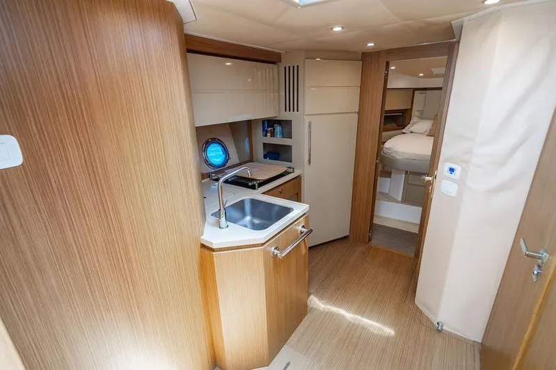 Endurance Yacht Photos Pics Interior of 2016 Azimut Atlantis 50 yacht, featuring a compact kitchen and cozy bedroom.