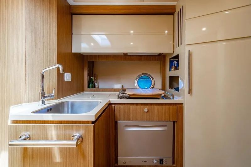 Endurance Yacht Photos Pics Modern kitchen interior of 2016 Azimut Atlantis 50 yacht with wood finish and porthole.