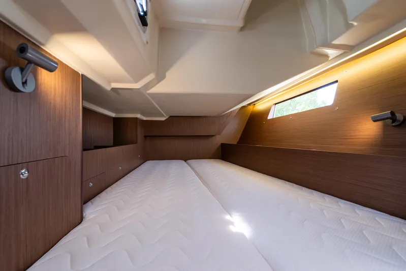  Yacht Photos Pics Interior cabin of 2020 Beneteau Oceanis 41.1 yacht, featuring twin beds and wooden paneling.