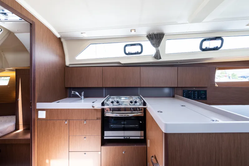  Yacht Photos Pics Modern kitchen interior of 2020 Beneteau Oceanis 41.1 yacht with wood finish and appliances.