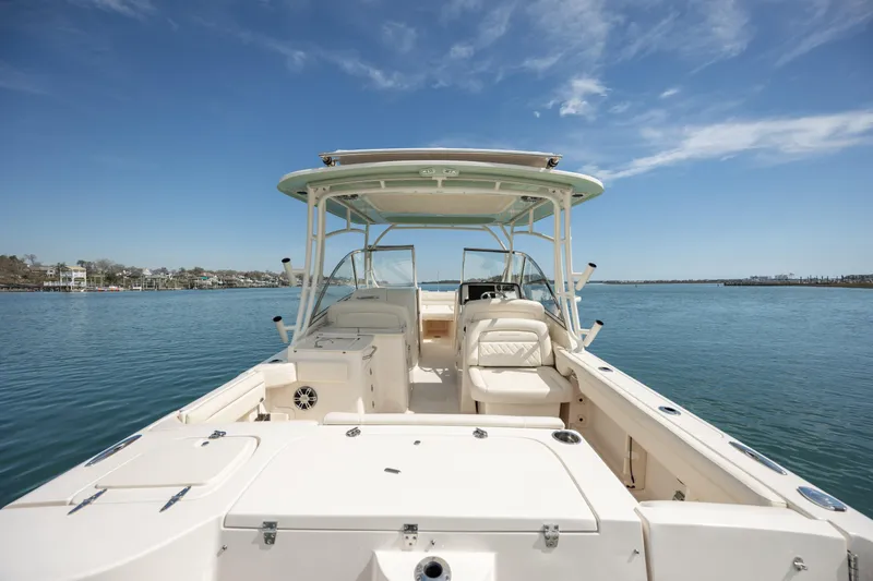  Yacht Photos Pics 2023 Grady-White Freedom 285 boat on calm water under a clear blue sky.