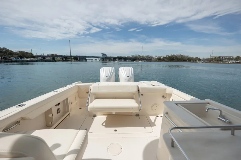  Yacht Photos Pics 2023 Grady-White Freedom 285 boat on calm water, featuring spacious deck and seating.