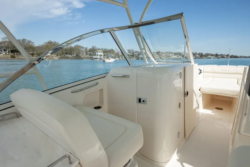  Yacht Photos Pics 2023 Grady-White Freedom 285 boat interior with seating, on a calm waterway.