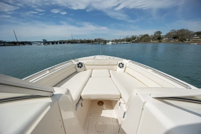  Yacht Photos Pics 2023 Grady-White Freedom 285 boat on calm water, showcasing spacious seating and sleek design.