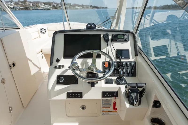  Yacht Photos Pics 2023 Grady-White Freedom 285 boat dashboard with steering wheel and navigation controls.
