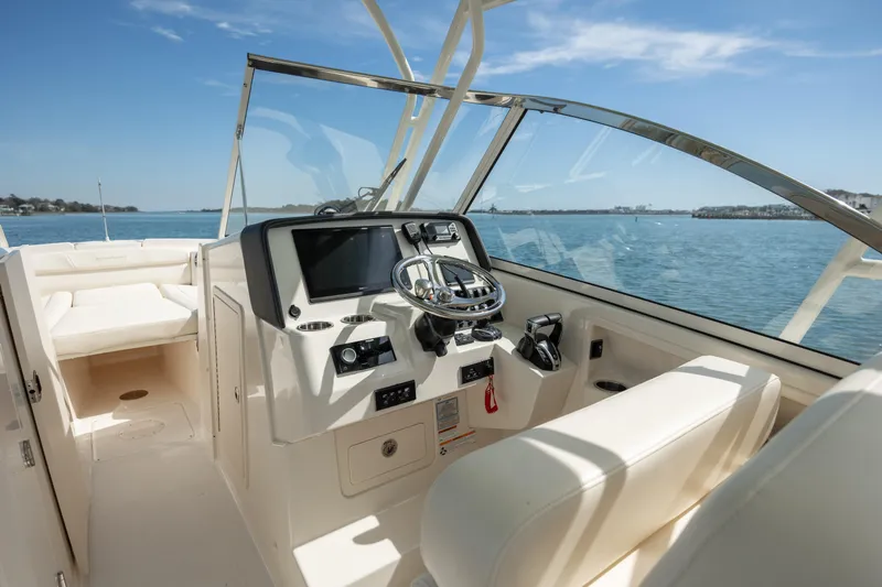  Yacht Photos Pics 2023 Grady-White Freedom 285 boat interior with steering console, on a sunny day at sea.