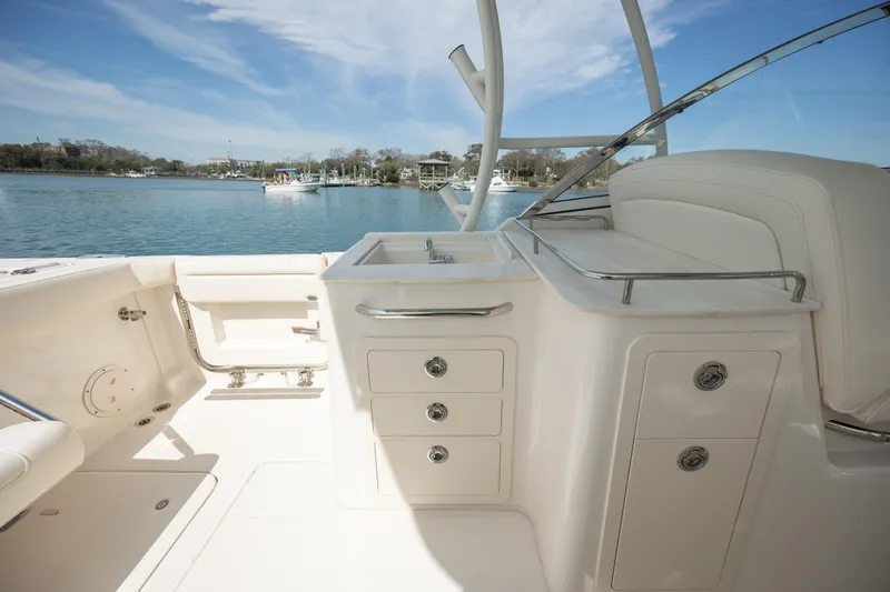  Yacht Photos Pics 2023 Grady-White Freedom 285 boat interior with storage and sink, overlooking a serene water view.
