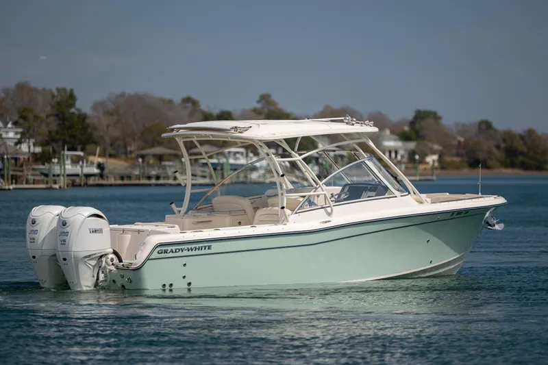  Yacht Photos Pics 2023 Grady-White Freedom 285 boat on calm water, showcasing sleek design and dual engines.