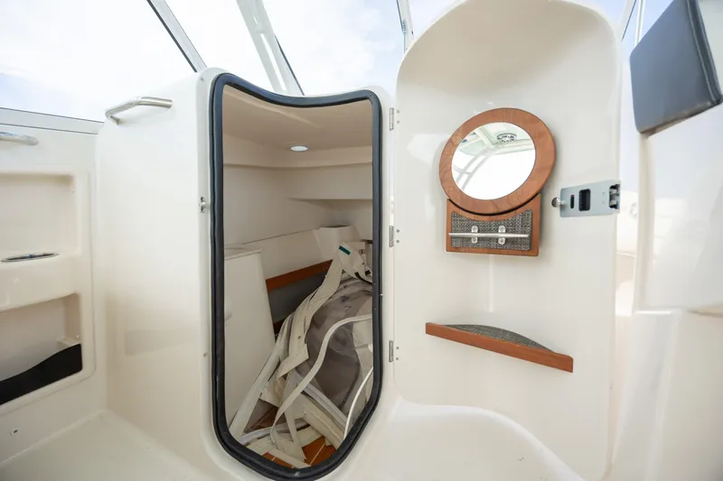  Yacht Photos Pics 2023 Grady-White Freedom 285 boat interior with storage and mirror.