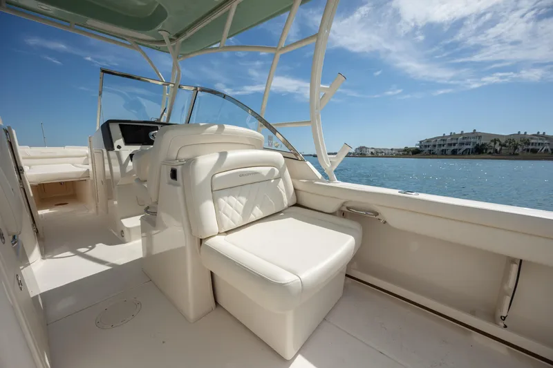  Yacht Photos Pics 2023 Grady-White Freedom 285 boat interior with seating, overlooking a scenic waterfront.
