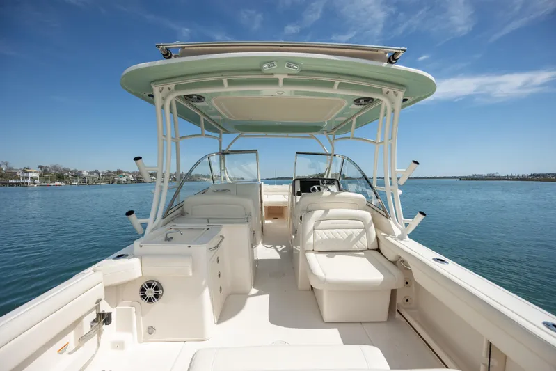  Yacht Photos Pics 2023 Grady-White Freedom 285 boat interior with seating, on a calm blue water backdrop.