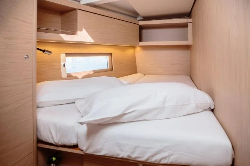  Yacht Photos Pics Cozy cabin interior of 2019 Beneteau Oceanis 46.1 yacht with comfortable bedding.
