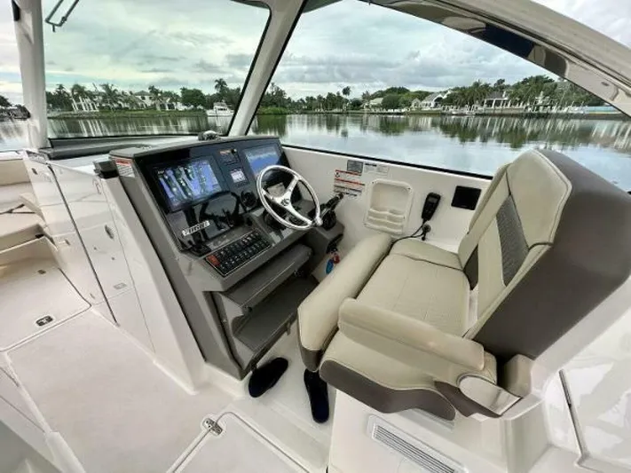  Yacht Photos Pics 2019 Pursuit DC 325 Dual Console boat interior with helm, steering wheel, and navigation screens.
