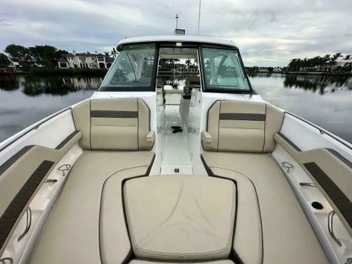  Yacht Photos Pics 2019 Pursuit DC 325 Dual Console boat with beige seating, docked on a calm lake.
