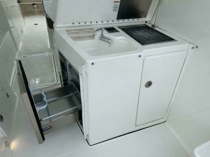  Yacht Photos Pics 2019 Pursuit DC 325 Dual Console boat kitchenette with sink, grill, and storage drawers.
